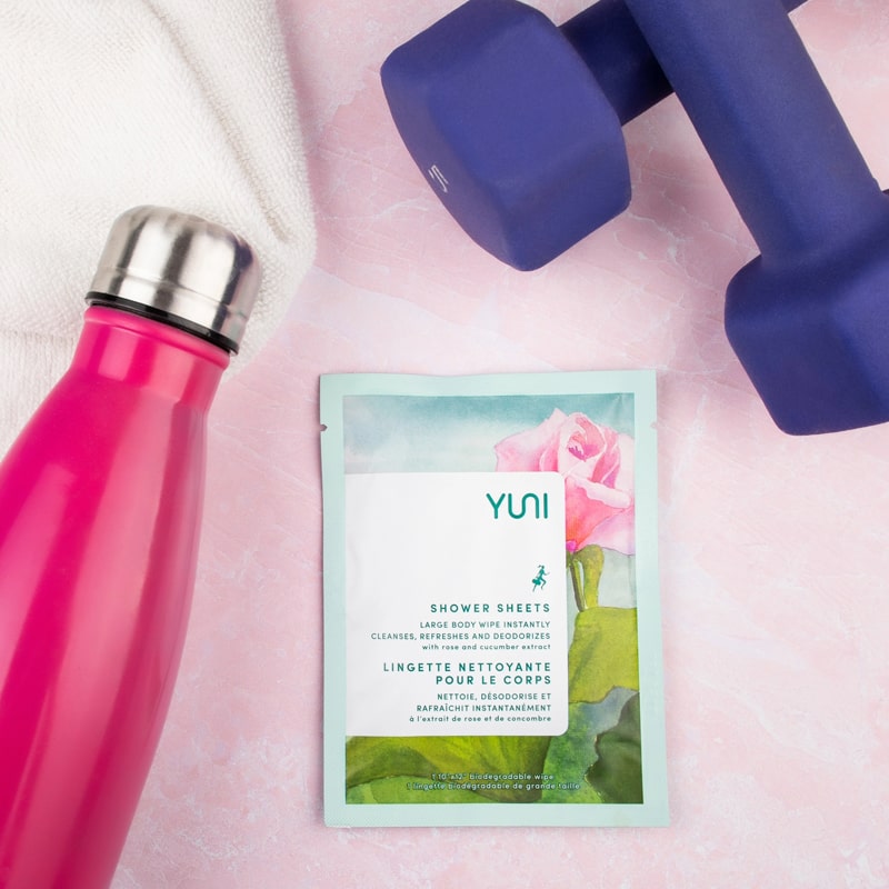 YUNI Beauty Yuni Rose Cucumber Shower Sheets Large Body Wipes - product next to water bottle and weights