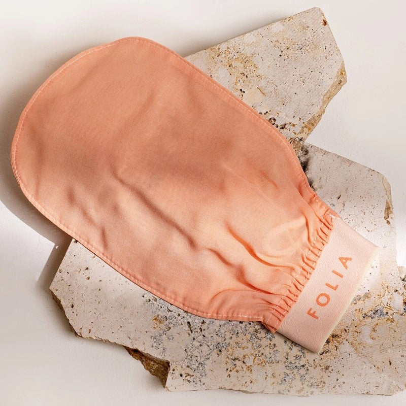 Folia Body Exfoliating Body Mitt - product shown on top of stone slab