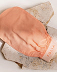 Folia Body Exfoliating Body Mitt - product shown on top of stone slab