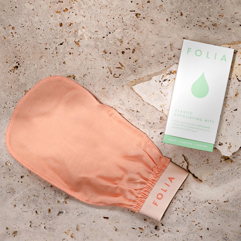 Folia Body Exfoliating Body Mitt - product shown on stone