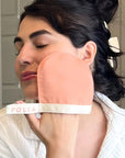 Folia Body Exfoliating Face Mitt - model shown using product on face