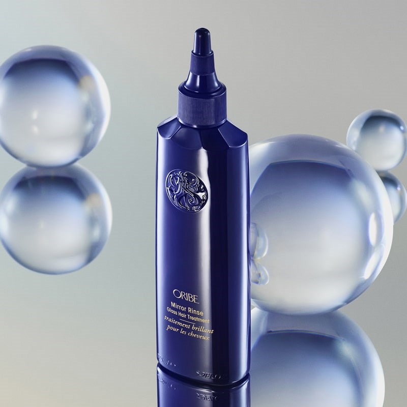 Oribe Mirror Rinse Glass Hair Treatment - product shown next to glass orbs 