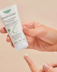 Embryolisse Mattifying Moisturizer - model holding product with cream on finger