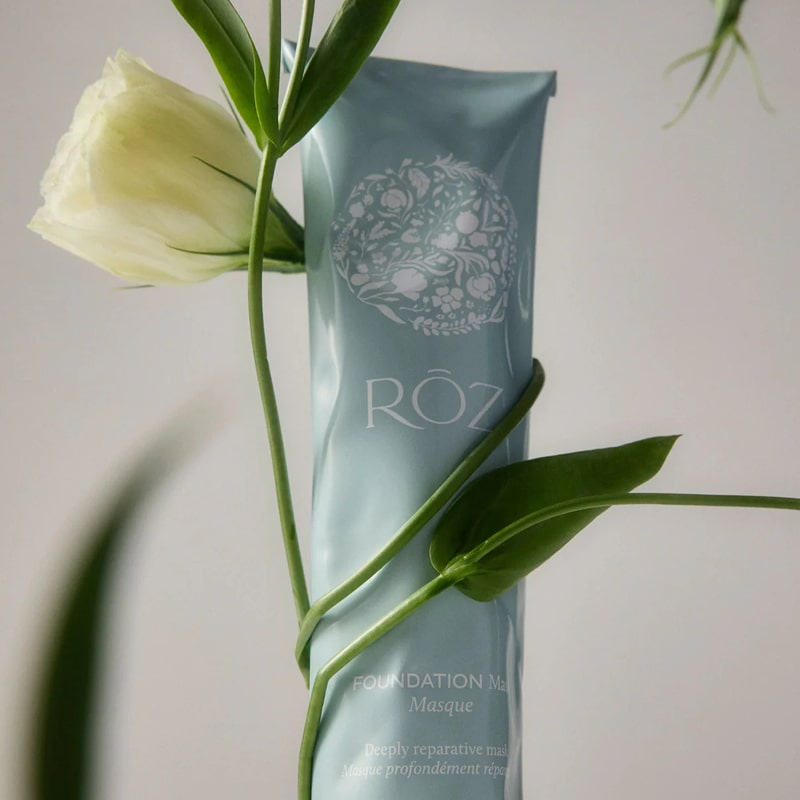 Roz Foundation Mask - product shown with plant wrapped around it