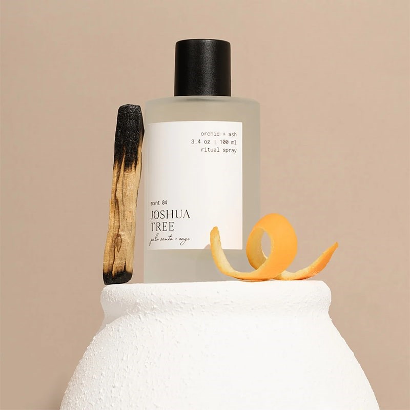 Orchid + Ash Joshua Tree Ritual Spray - product shown next to orange peel and palo santo stick on top of ceramics