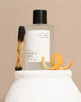 Orchid + Ash Joshua Tree Ritual Spray - product shown next to orange peel and palo santo stick on top of ceramics