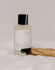 Orchid + Ash Joshua Tree Ritual Spray - product shown next to burning palo santo stick on fabric