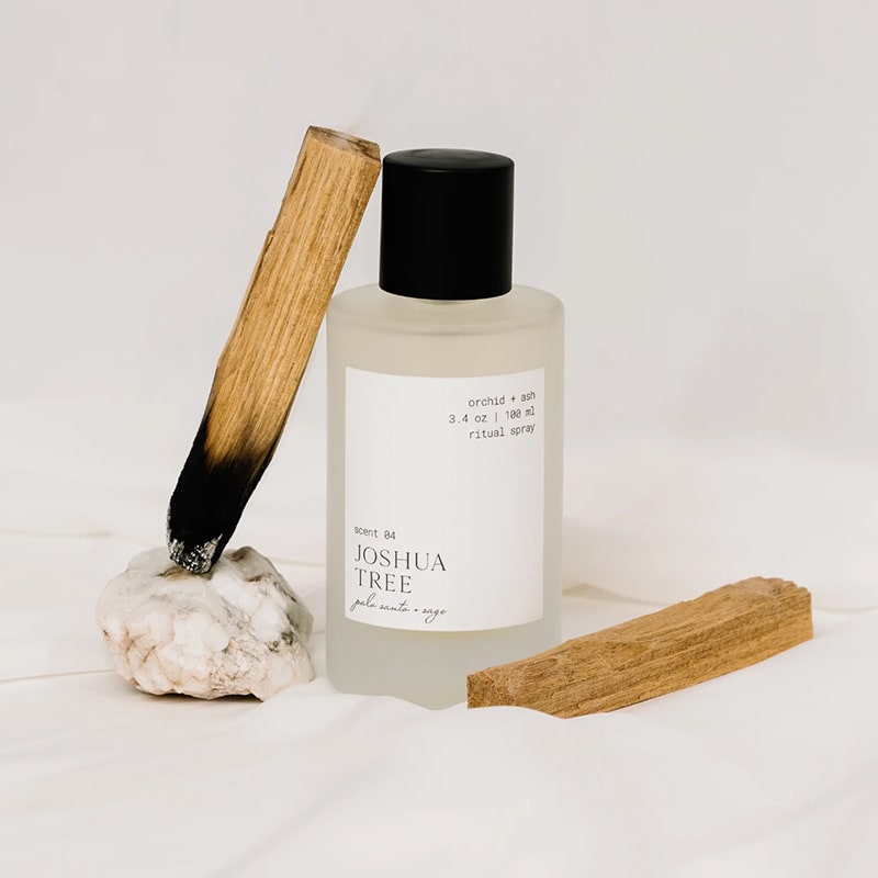 Orchid + Ash Joshua Tree Ritual Spray - product shown next to palo santo sticks and rock