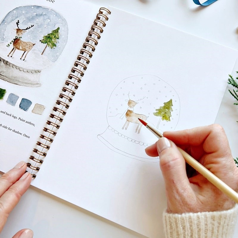 Emily Lex Studio Winter Watercolor Workbook - model shown painting inside product