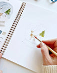 Emily Lex Studio Winter Watercolor Workbook - model shown painting inside product