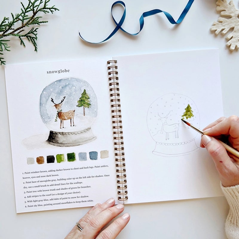 Emily Lex Studio Winter Watercolor Workbook - model shown painting inside product