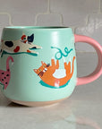 Idlewild Co Cats Ceramic Mug - product shown on countertop 