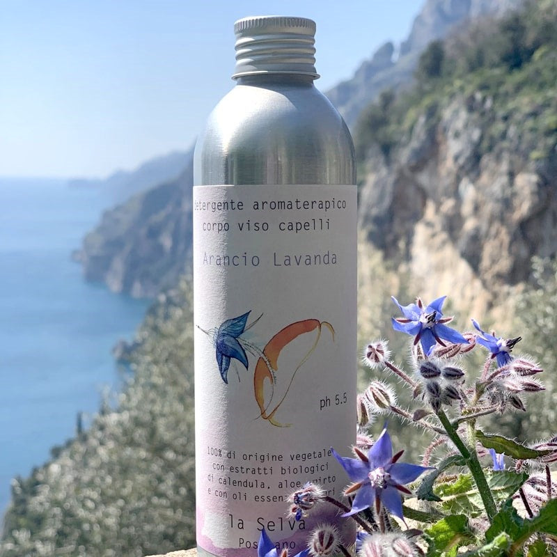 La Selva Positano Orange and Lavender Aromatherapy Cleanser - product shown on cliffside with flowers