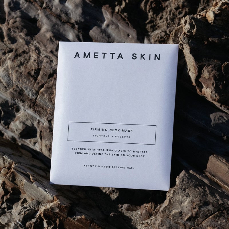 Ametta Skin Firming Neck Mask - product packaging shown on rocks