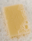 Poetica Lemon Myrtle & Cardamom Botanical Garment Bar Soap (3 oz) - Product shown in water with soap bubbles