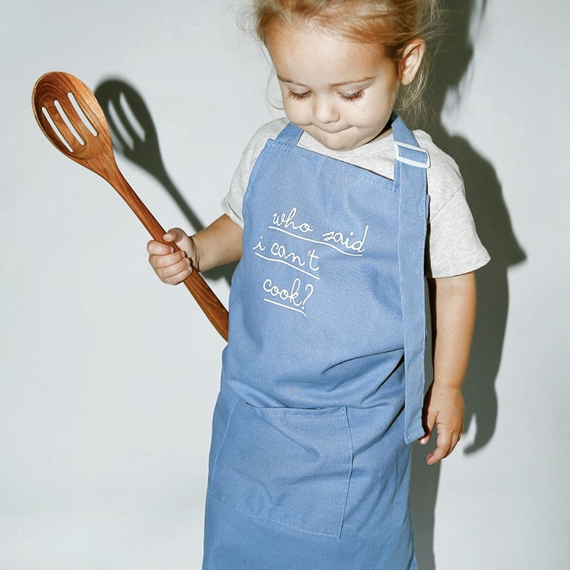 Little girl wearing POP Party Supplies Little Chef Embroidered Linen Cooking Apron