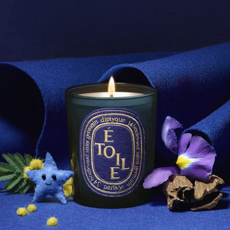 Diptyque Limited Edition Etoile Candle - lit product shown next to fragrance ingredients and felt