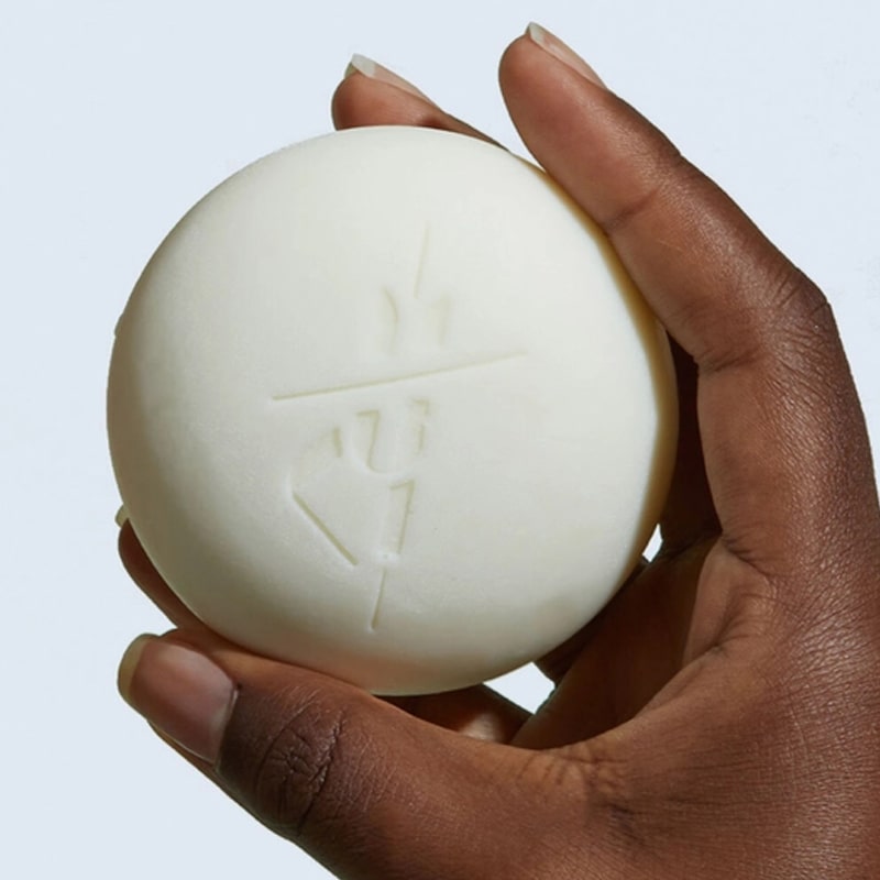 Close up of model holding Kate McLeod Daily Stone Deep Moisturizing Lotion Bar (3.5 oz)