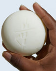 Close up of model holding Kate McLeod Daily Stone Deep Moisturizing Lotion Bar (3.5 oz)