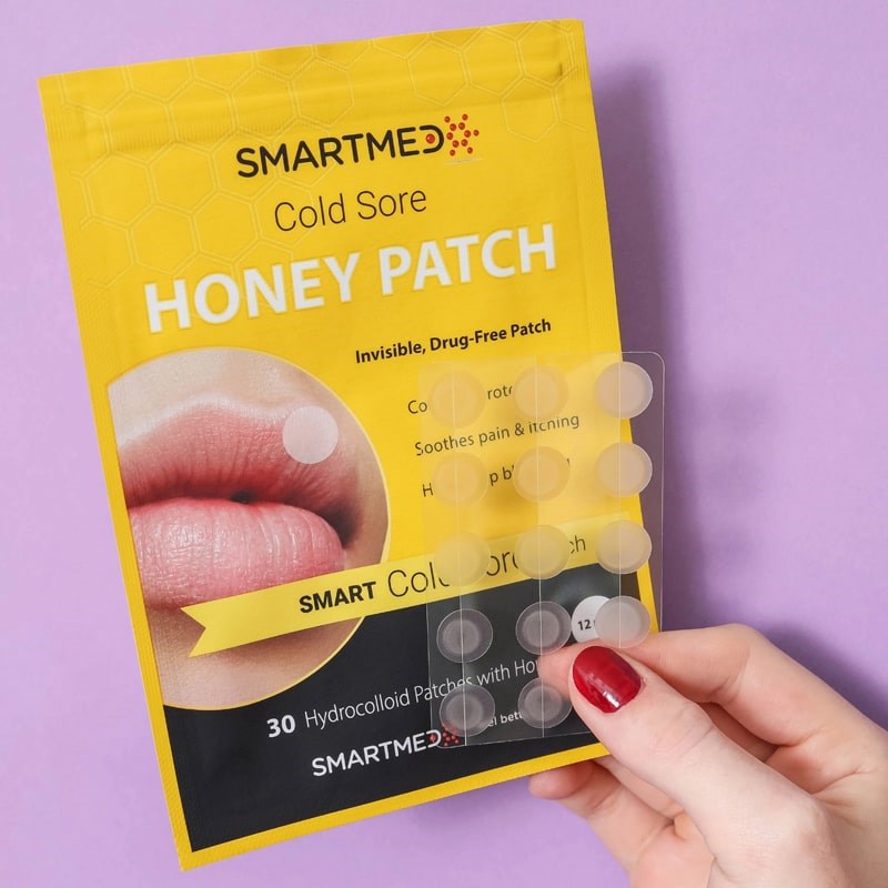 SMARTMED Smart Cold Sore Treatment Patch with Honey (30 patches) - model holding one sheet of patches with packaging in the background