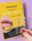 SMARTMED Smart Cold Sore Treatment Patch with Honey (30 patches) - model holding one sheet of patches with packaging in the background