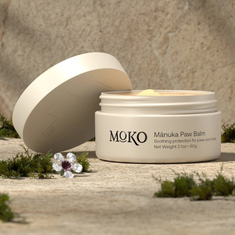 Moko Manuka Paw Balm - product shown with lid off next to flowers