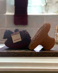 Cinq Mondes Moroccan Clay Pumice Stone Foot Exfoliant - product shown next to included bag in bathroom