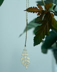 Fog Linen Work Brass Leaf - K - product shown hanging from plant