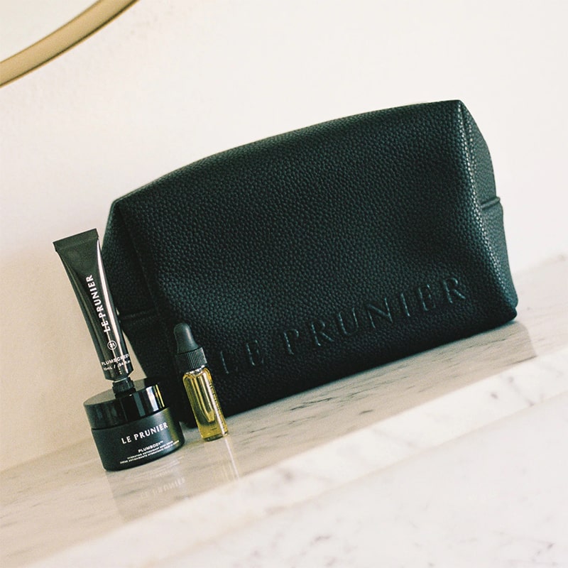 Le Prunier The Signature Mini Set - products shown next to toiletry bag