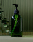 Koala Eco Apothecary Glass Bottle and Pump - product shown in front of glass and plant