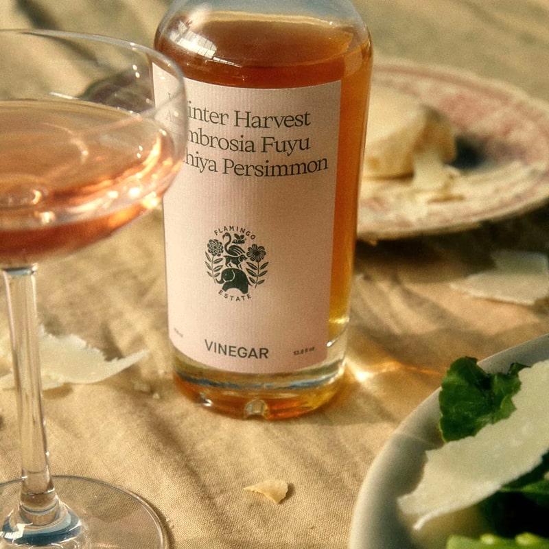 Flamingo Estate Organics Winter Harvest Persimmon Vinegar - product shown next to glass and plate of food