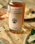 Flamingo Estate Organics Winter Harvest Persimmon Vinegar - product shown next to glass and plate of food