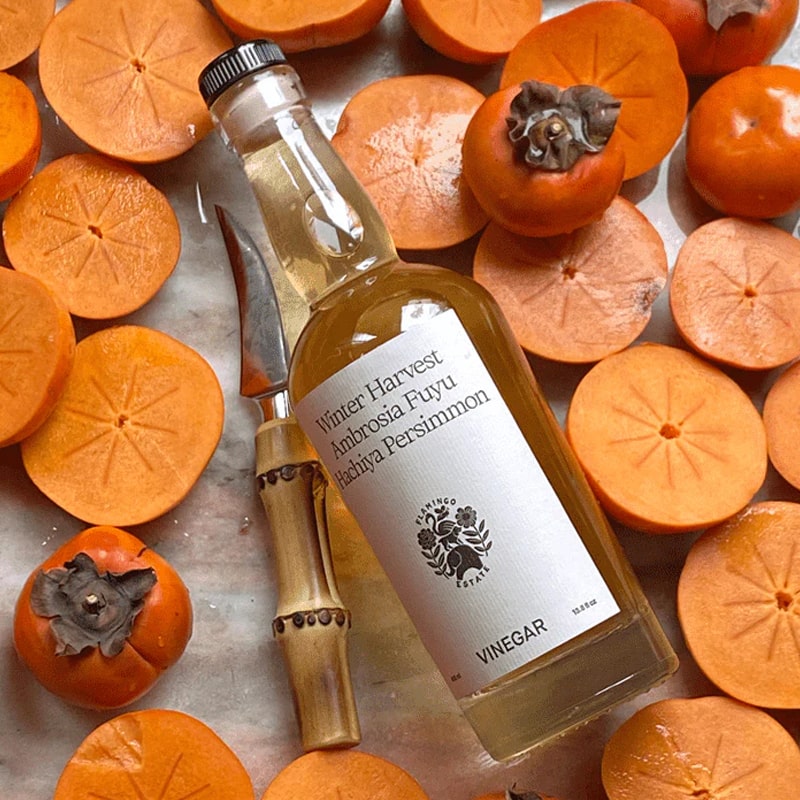 Flamingo Estate Organics Winter Harvest Persimmon Vinegar - product shown next to to sliced persimmons