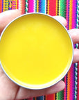 Model holding open jar of Peruvian Gold Organic Skin Healing Balm (2 oz)