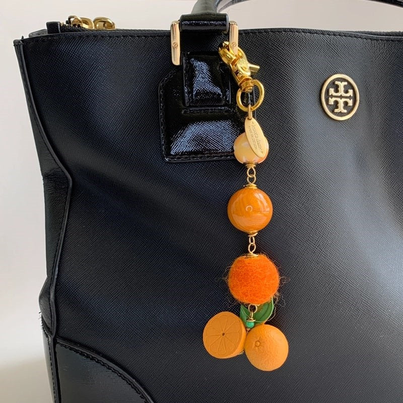 Lenora Dame Freshly Squeezed Orange Bag Charm - product shown attached to purse