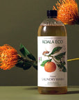 Koala Eco Natural Laundry Wash - Mandarin and Peppermint - product shown in front of flowers