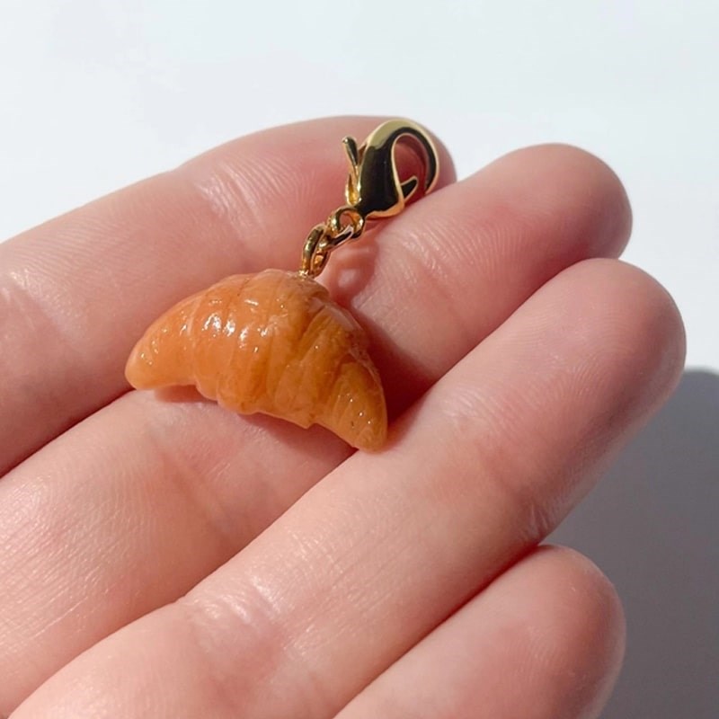 Bold Blossom Shop Croissant Bag Charm - model shown holding product