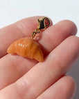 Bold Blossom Shop Croissant Bag Charm - model shown holding product