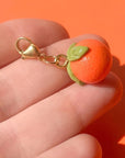 Bold Blossom Shop Tangerine Bag Charm - model shown holding product