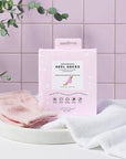 VOESH New York Moisturizing Heel Socks - Pink - products shown next to packaging and towel