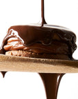 Wooden Table Baking Company Chocolate Covered Alfajores Cookies - product shown on wooden spoon with chocolate dripping on it