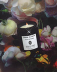 Sangre de Fruta Head of Roses Botanical Candle - lit product shown with roses and flowers