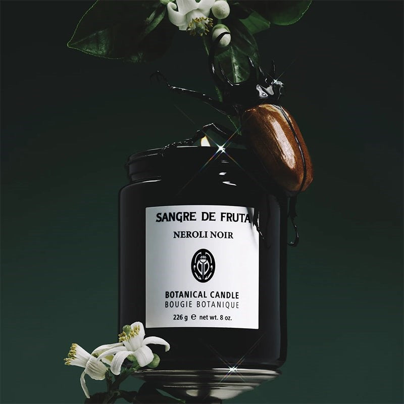 Sangre de Fruta Neroli Noir Botanical Candle - product shown with flowers and beetle 