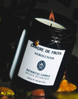 Sangre de Fruta Neroli Noir Botanical Candle - lit product shown with ladybug and flowers