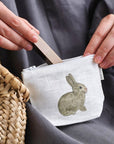 Lifestyle shot, close up of model placing lipstick in Fog Linen Work Isabelle Boinot Pouch - Rabbit and Carrot