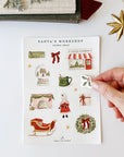 Emily Lex Studio Santa's Workshop Sticker Sheets - model taking product off sheet next to books and star