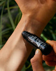 Close up of model applying Ofa Karri Peaceful Mind Roll-On (10 ml) to wrist