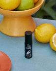 Lifestyle shot of Ofa Karri Peaceful Mind Roll-On (10 ml) with lemons in the background