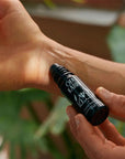 Model applying Ofa Karri Cycle Balance Roll-On (10 ml) to wrist