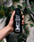 Model holding Ofa Karri Deep Harmony Home Spray (200 ml) with leaves in the background